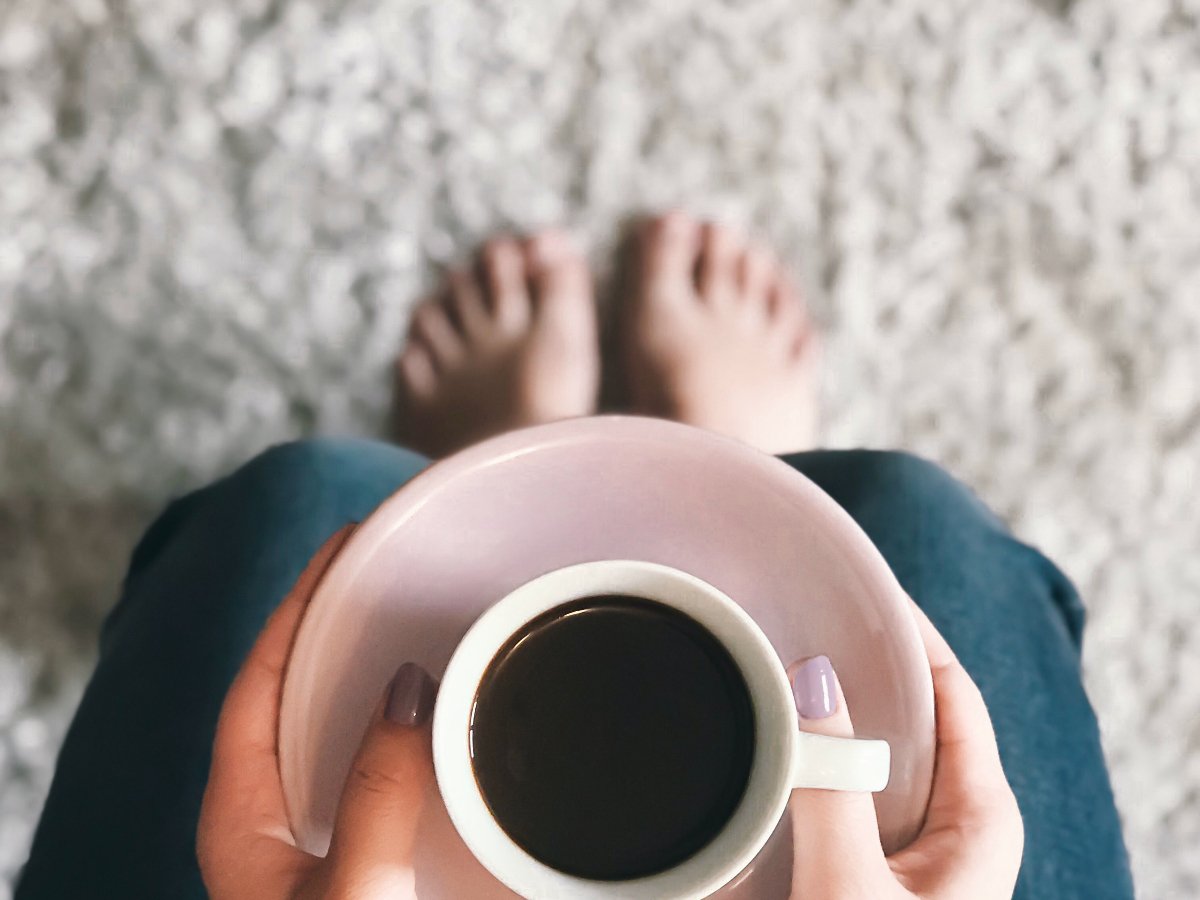 person holding cup of coffee on carpet - Americarpets of Layton, UT
